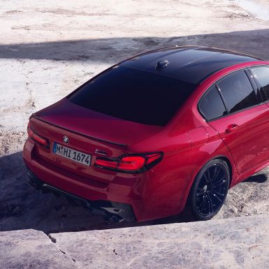 BMW M5 Competition F90 LCI Facelift 2020, вид сзади в три четверти сверху BMW M5 Competition F90 LCI Facelift 2020, BMW Individual "Красный Имола", вид сзади в три четверти сверху