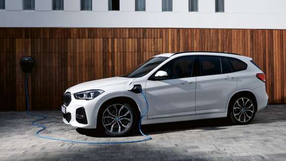 Подключаемый гибрид BMW X1 xDrive25e F48 LCI, вид сбоку в три четверти Подключаемый гибрид BMW X1 xDrive25e F48 LCI, вид сбоку в три четверти при зарядке