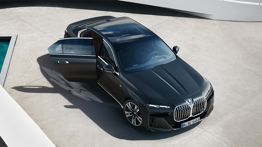 BMW 7 Сериялы Седан G70 ICE 740i M Sports пакеті, шанақ бояуы сұр металлик (Frozen Deep Grey), жолаушылар есігі ашық тұрғанда үстінен көрінісі