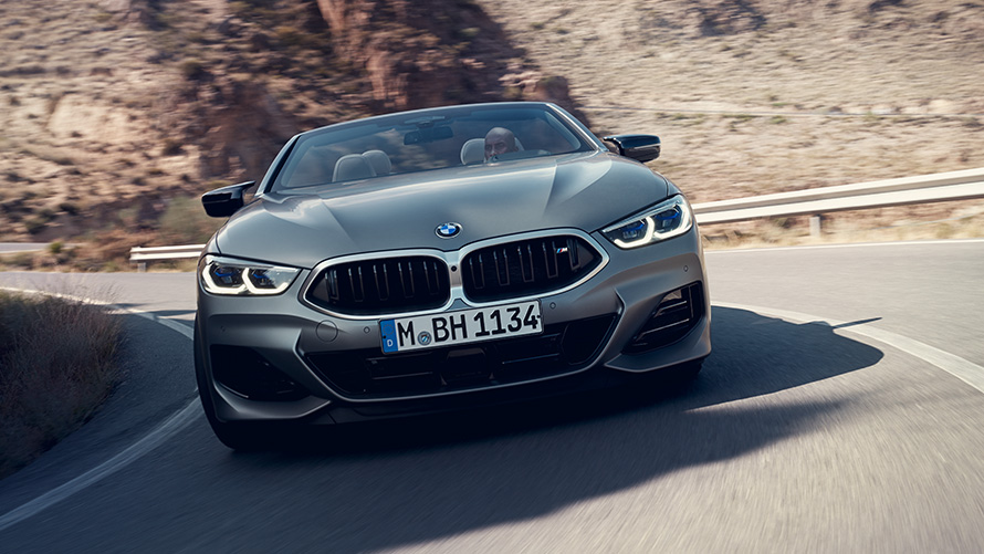 BMW 8 Серии Cabrio G14 LCI (рестайлинг 2022 года) с пакетом M Sport в базовой комплектации, вид спереди с поворотом BMW 8 Серии Cabrio G14 LCI (рестайлинг 2022 года) с пакетом M Sport в базовой комплектации, цвет BMW Individual Морозный Серый металлик, вид спереди с поворотом