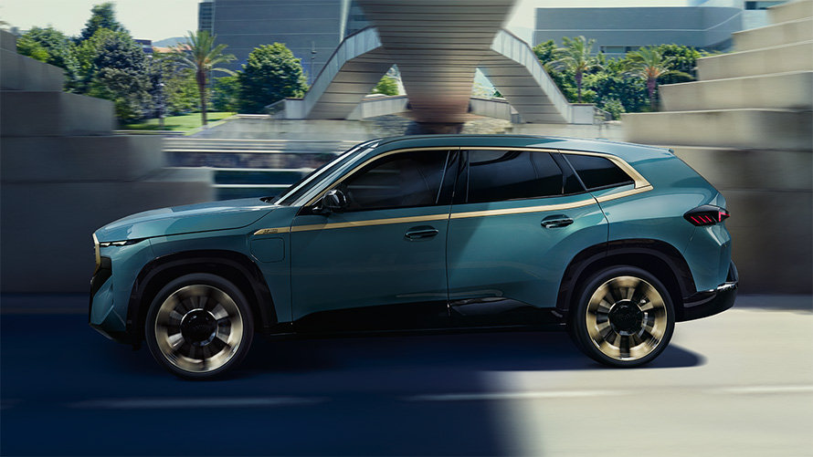 BMW XM G09, экстерьер, бүйір жағынан көрінісі, жүріп бара жатыр, Night Gold түсті акценттік сызығы