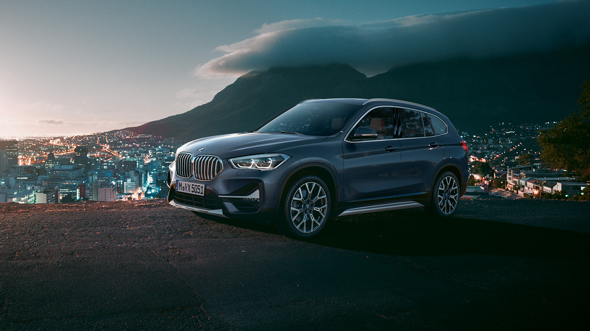 BMW X1, вид сбоку с поворотом в три четверти. BMW X1, вид сбоку с поворотом в три четверти на фоне городского пейзажа.