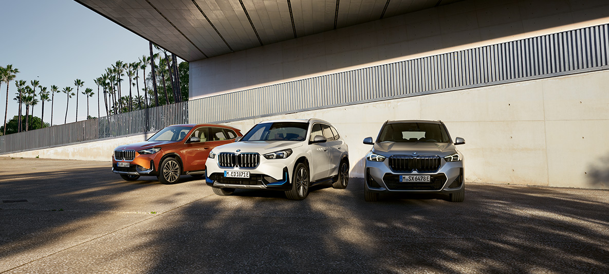 Портфолио продуктов BMW Специальные программы продаж Устойчивое развитие Экологический приоритет BMW Специальные программы продаж Устойчивое развитие Экологический приоритет Портфолио продуктов Три автомобиля BMW стоят рядом под путепроводом