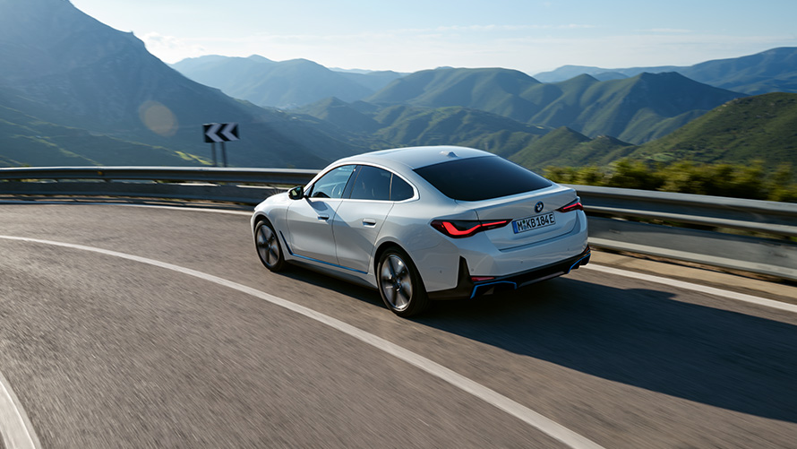 BMW Специальные программы продаж Устойчивое развитие Обзор Fleet Data Автомобиль BMW движется по дороге на фоне горного пейзажа