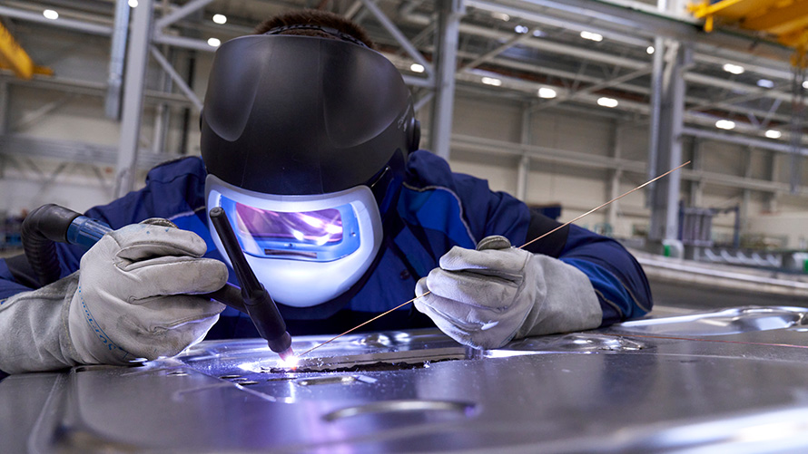 Условия для сотрудников BMW Специальные программы продаж Устойчивое развитие Социальный приоритет BMW Специальные программы продаж Устойчивое развитие Социальный приоритет Условия для сотрудников Человек в защитном костюме занимается сваркой