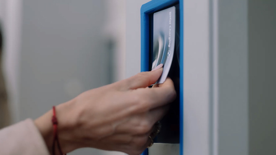 Человек использует карту BMW Charging на общественной зарядной станции